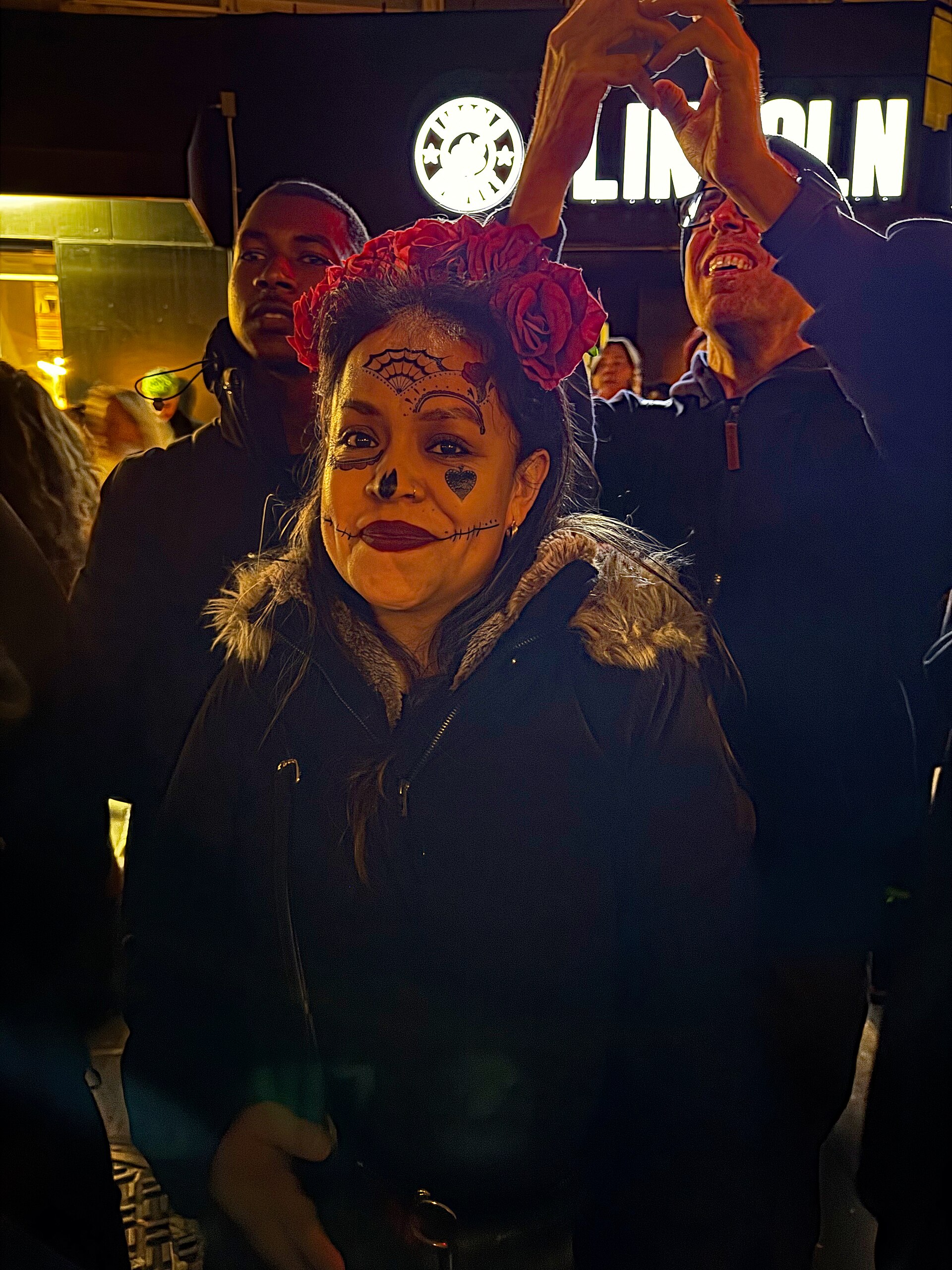 Donna con trucco da teschio e corona di fiori alla parata di Halloween