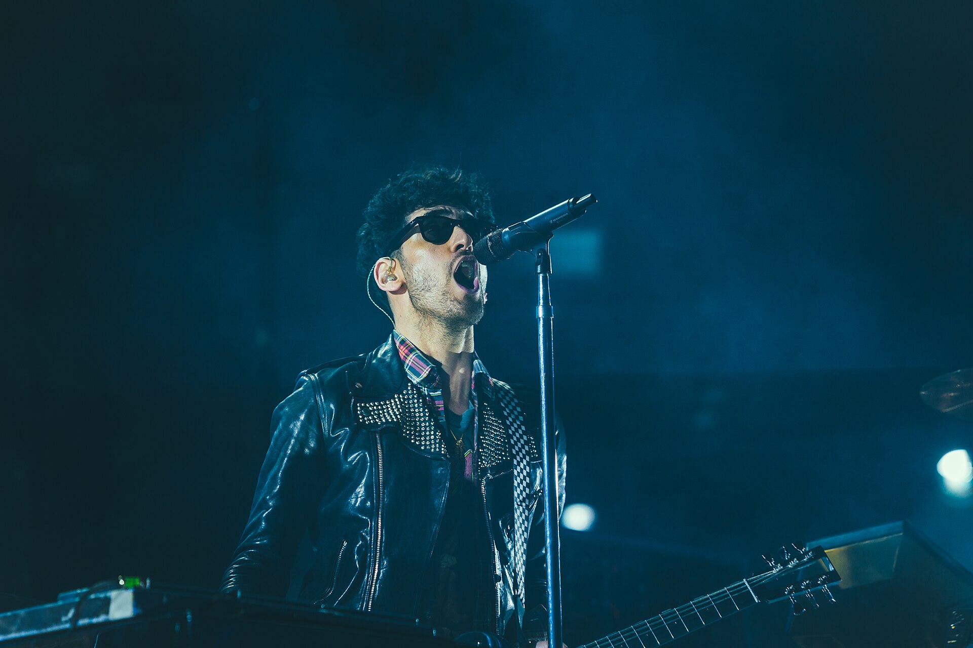 Una cantante si esibisce al microfono su un palco illuminato